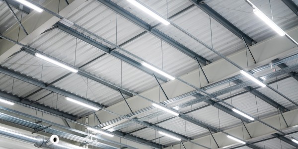 Rows of lighting on a warehouse ceiling.