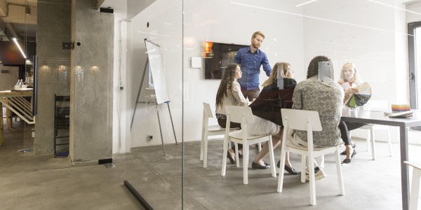 People sat around a meeting table in a modern office